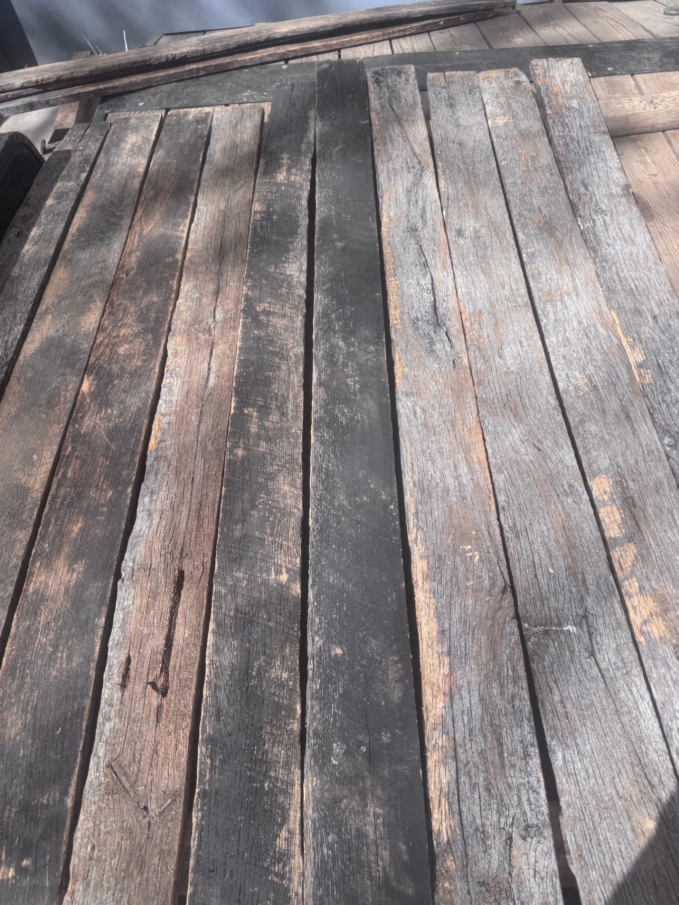 Mixed reclaimed 1-inch hardwood planks laid out in varied charcoal and brown tones