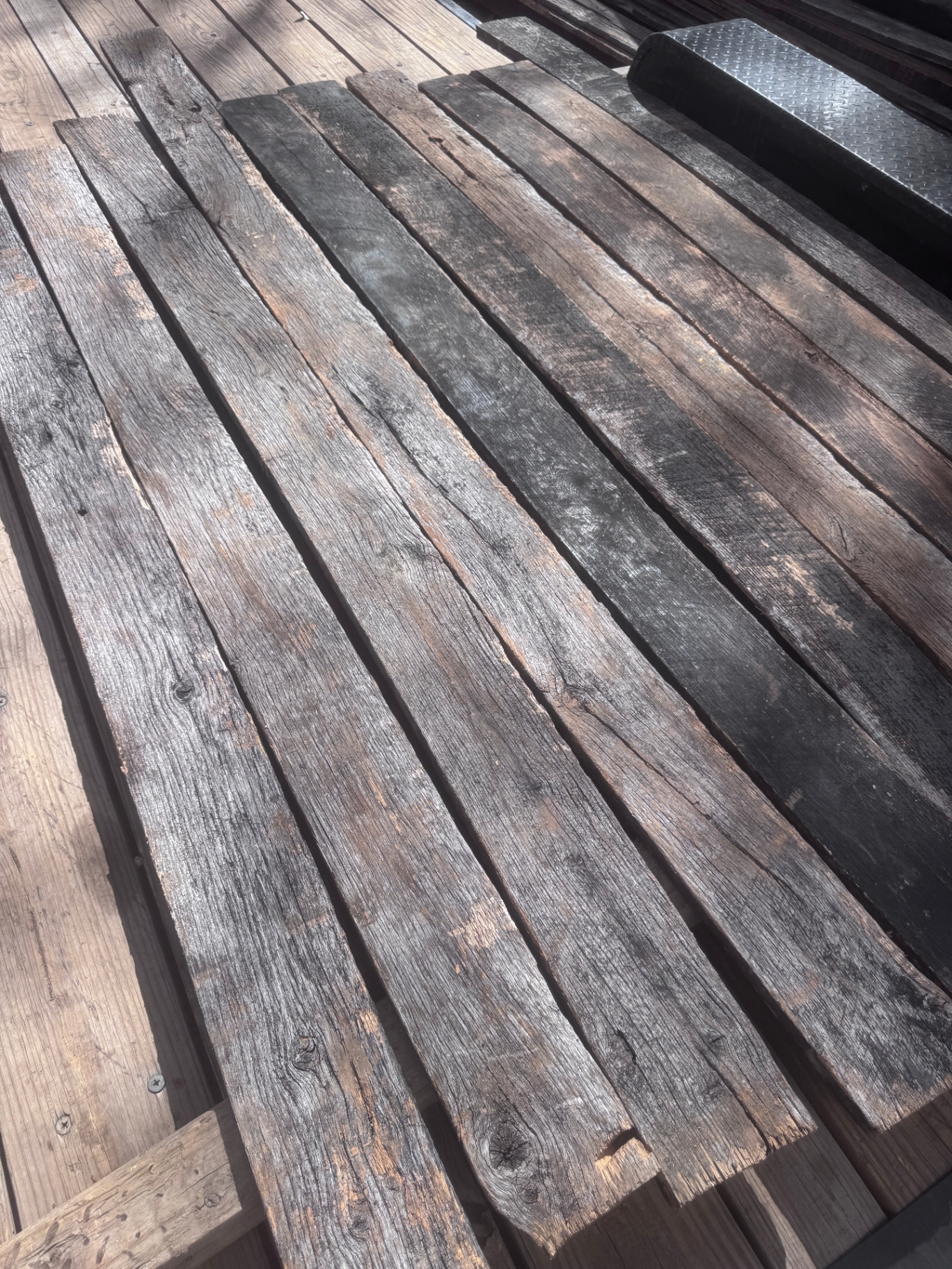 Long run of reclaimed 1-inch hardwood boards with dark weathered faces
