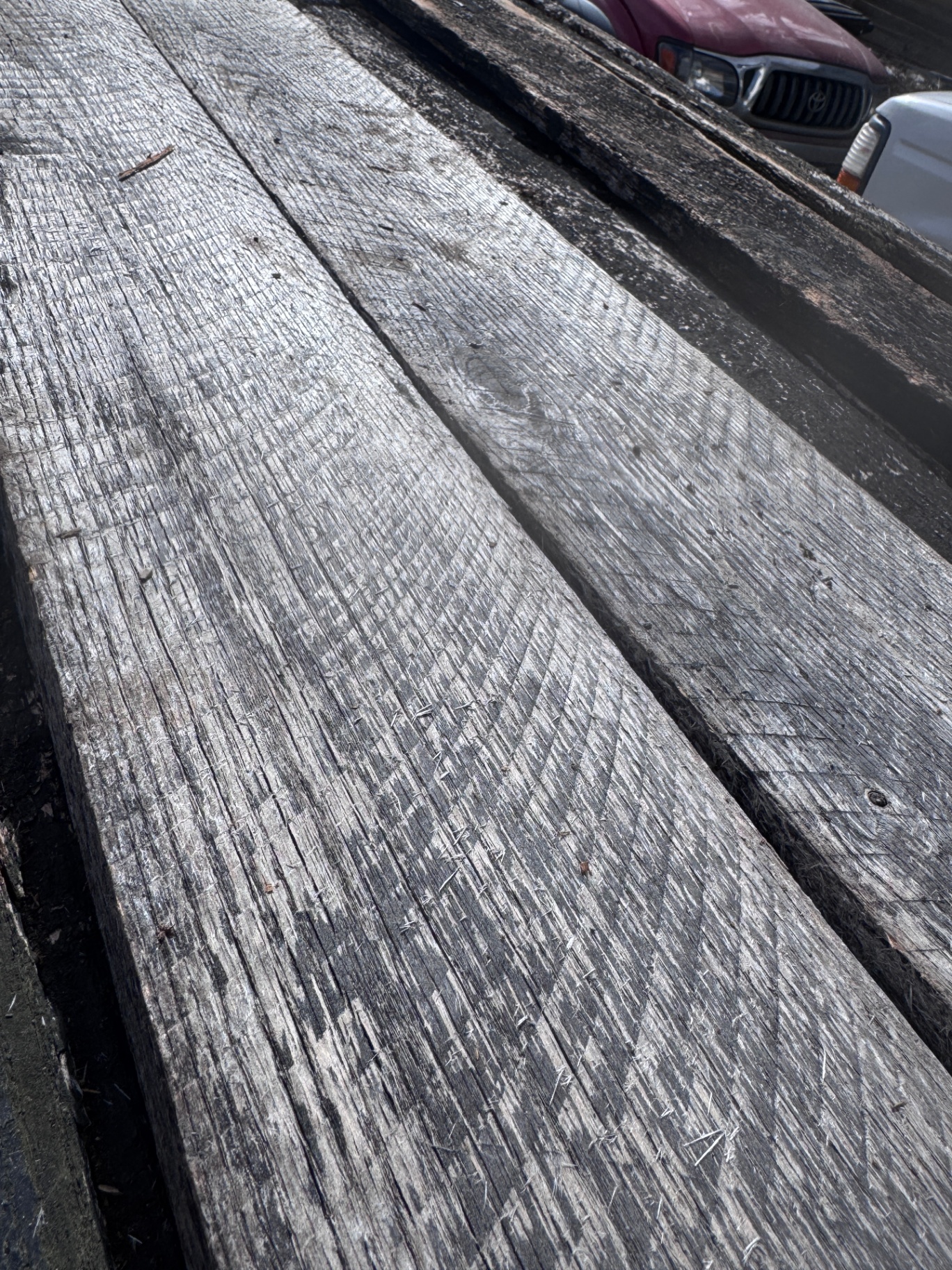 Silver-gray reclaimed 1-inch hardwood planks with visible saw texture and wear