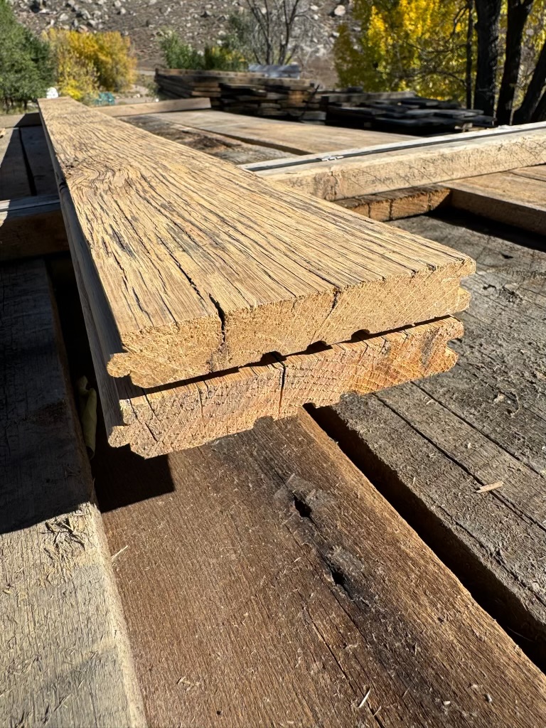 Profile end of milled reclaimed lumber boards with visible grain and interlocking edges