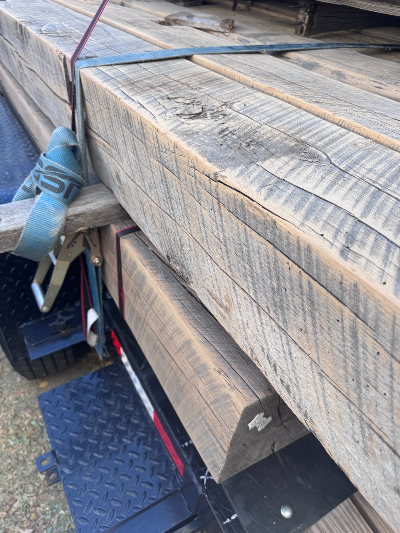 Bundled sanded reclaimed beams strapped on trailer with refined faces and aged edges