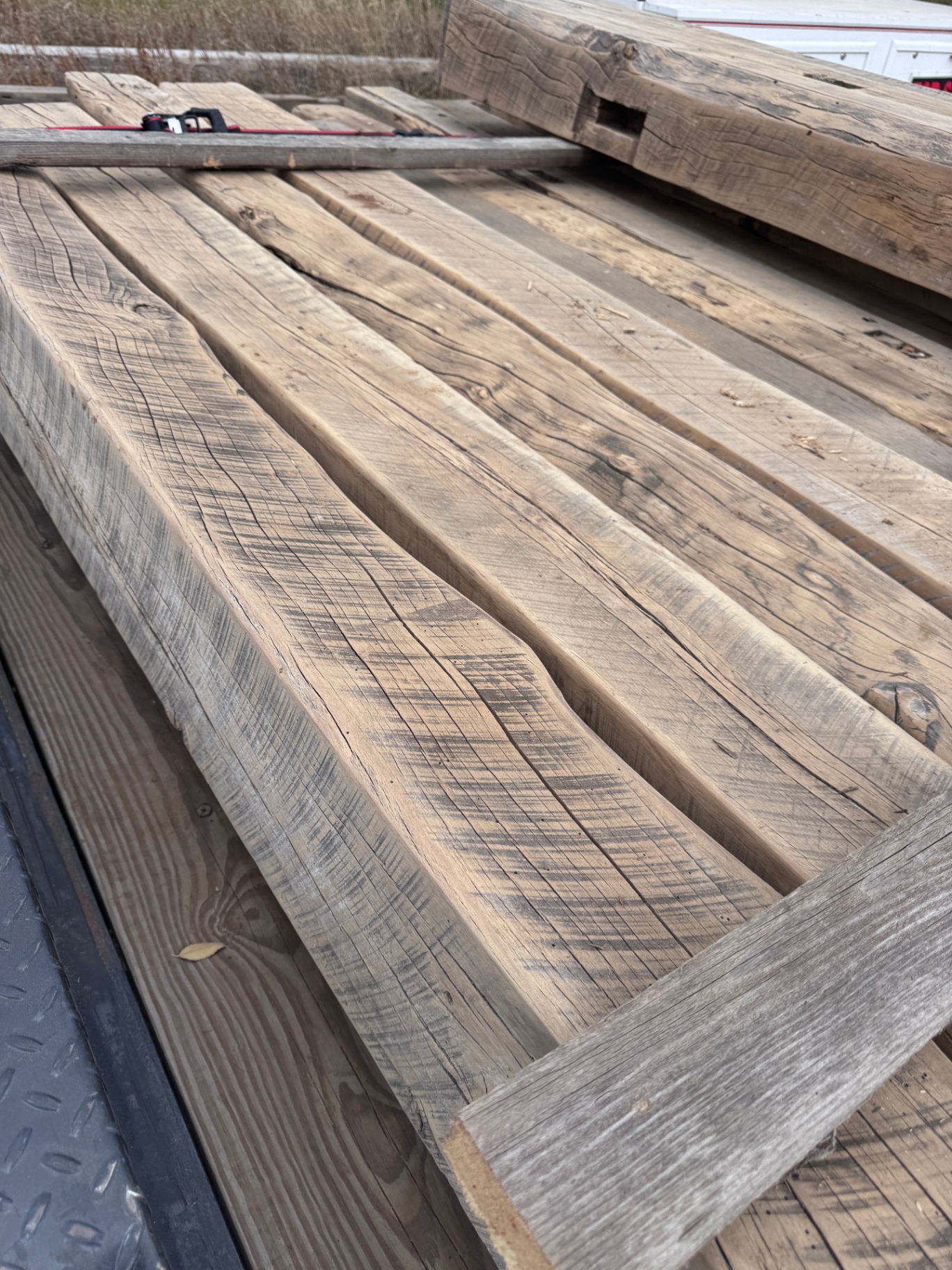 Row of sanded reclaimed planks laid out showing warm grain and checking