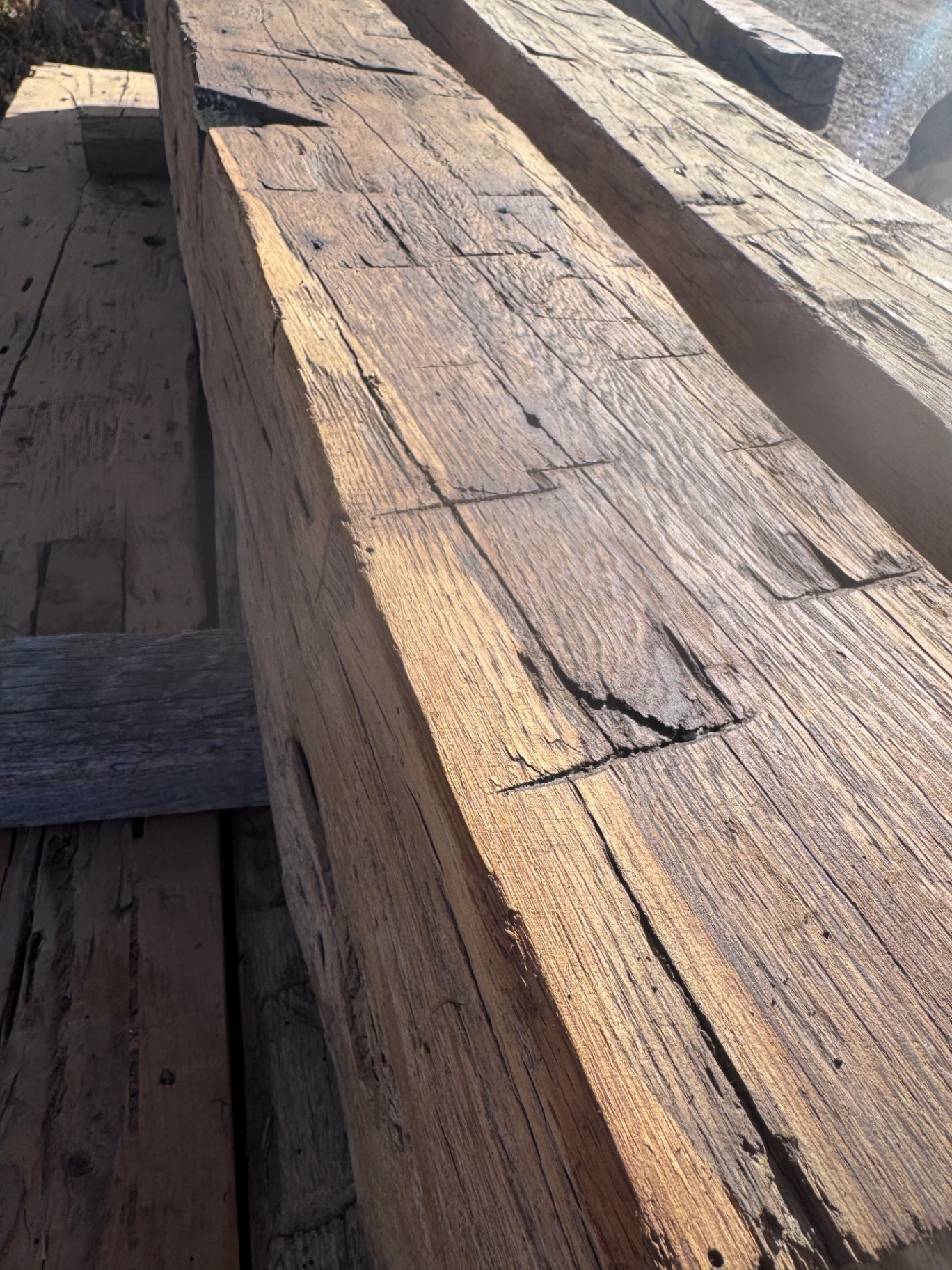 Top view of sanded reclaimed beams in sunlight with rich grain and natural patina