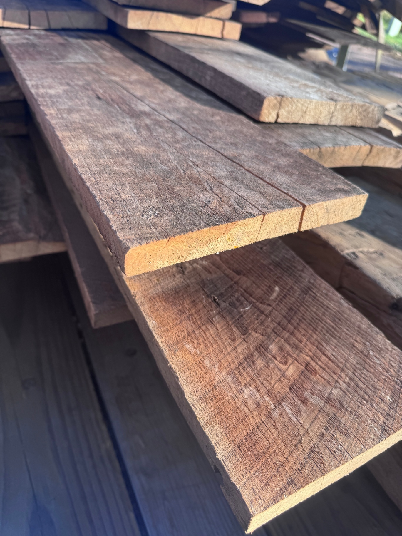 Rich brown reclaimed barnwood siding boards stacked in storage
