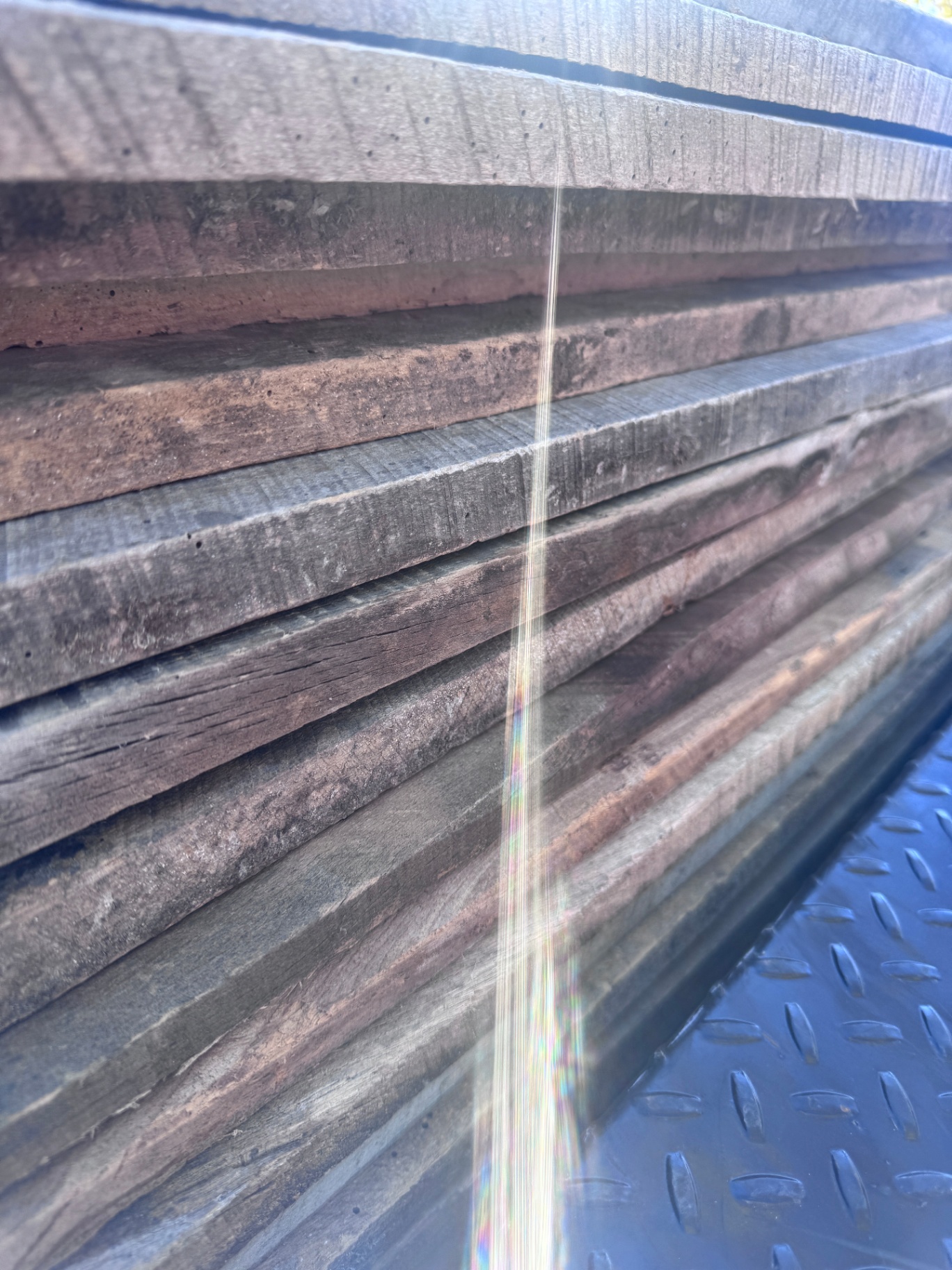 Edge view of stacked weathered barnwood siding showing layered patina