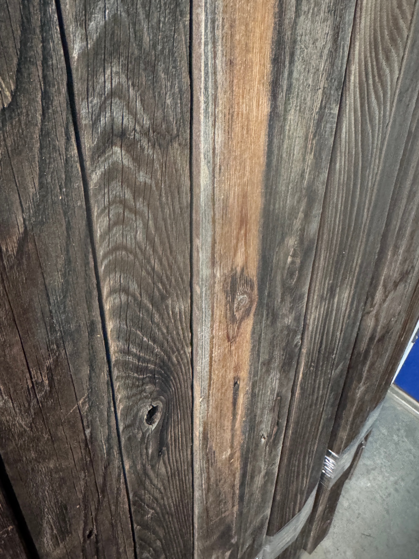 Close-up of weathered Colorado snow fencing boards showing silver-grey and warm caramel tones with deep grain