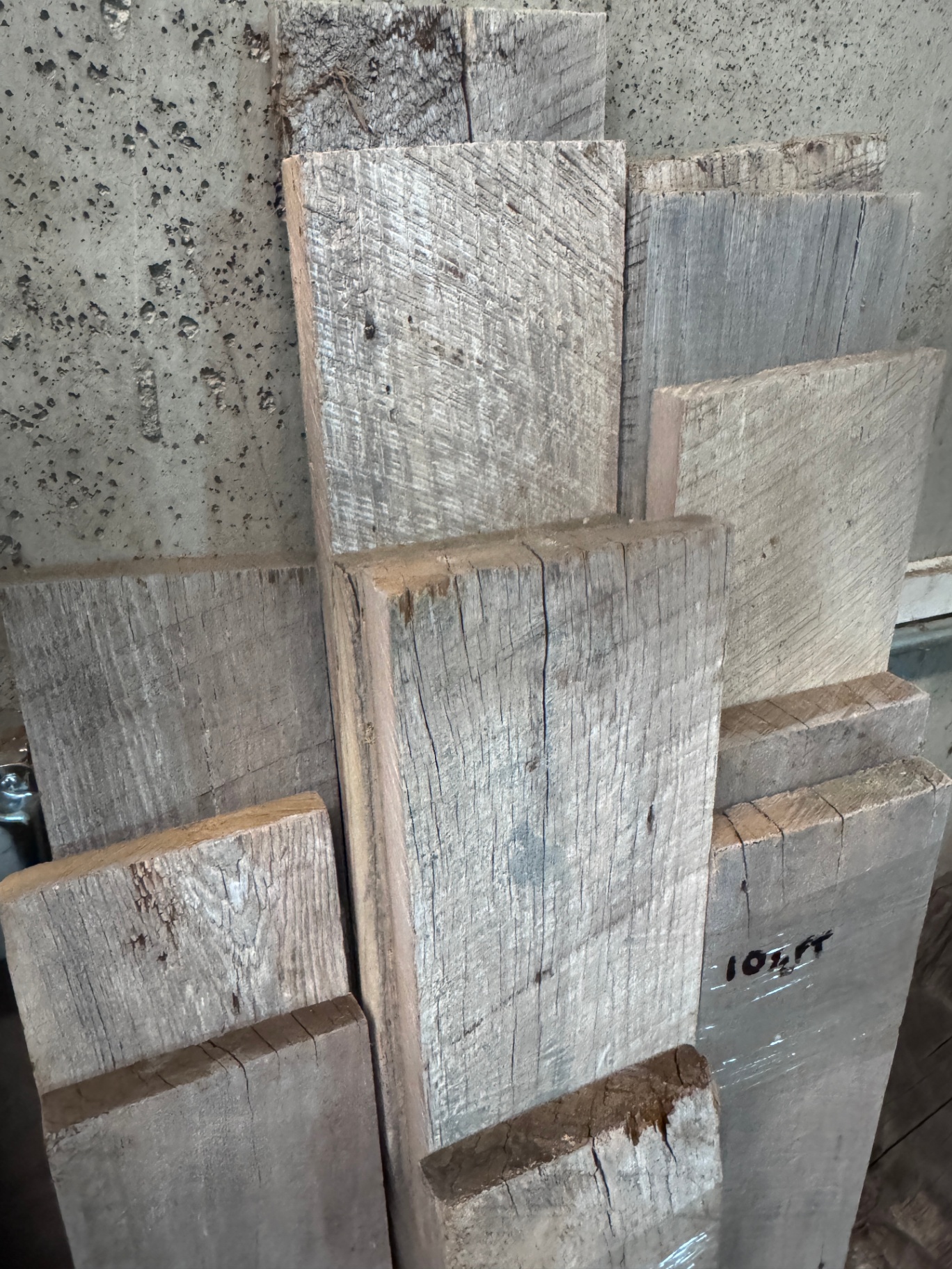 End-stacked snow fence boards showing silvered faces and rough-sawn edges